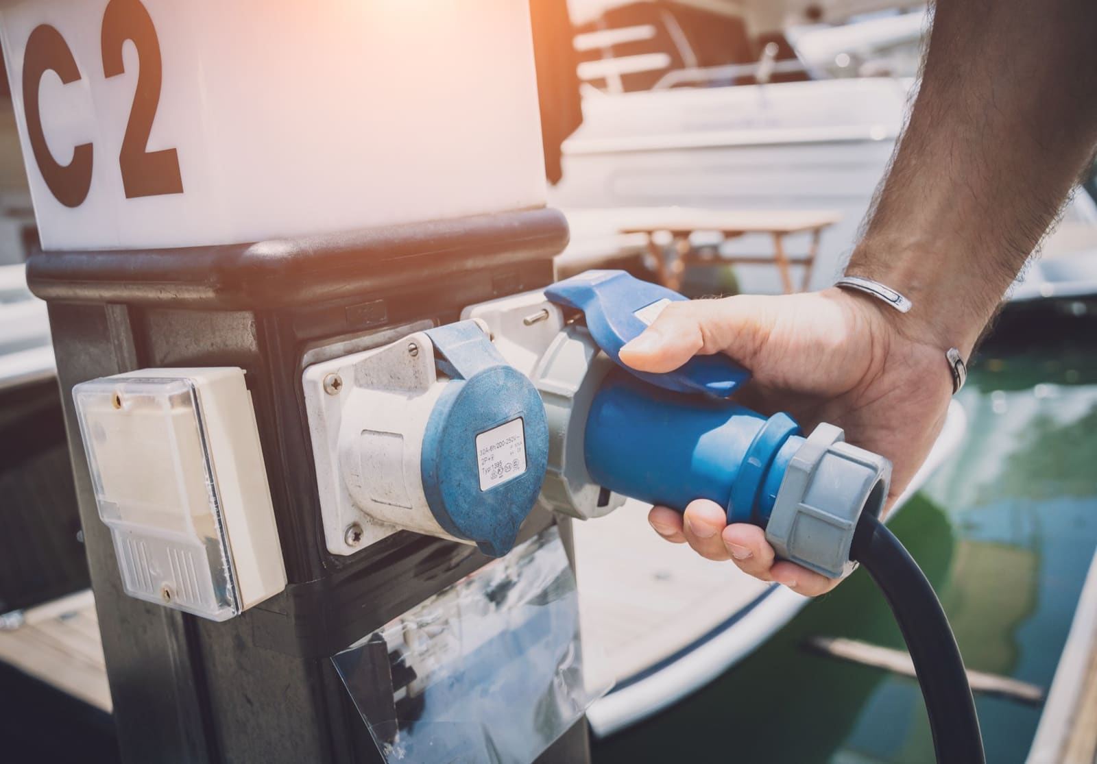 Smartphone met de VictronConnect-app open naast een Victron SmartShunt en Blue Smart-acculader aan boord